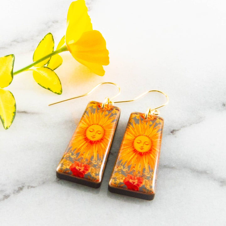 Vintage sunburst tapered rectangle wooden earrings with orange celestial sun and floral artwork