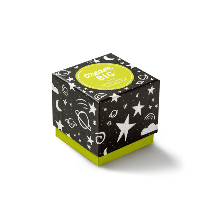 Black cube-shaped box with white space-themed illustrations and a green 'Dream Big' label on a white background.