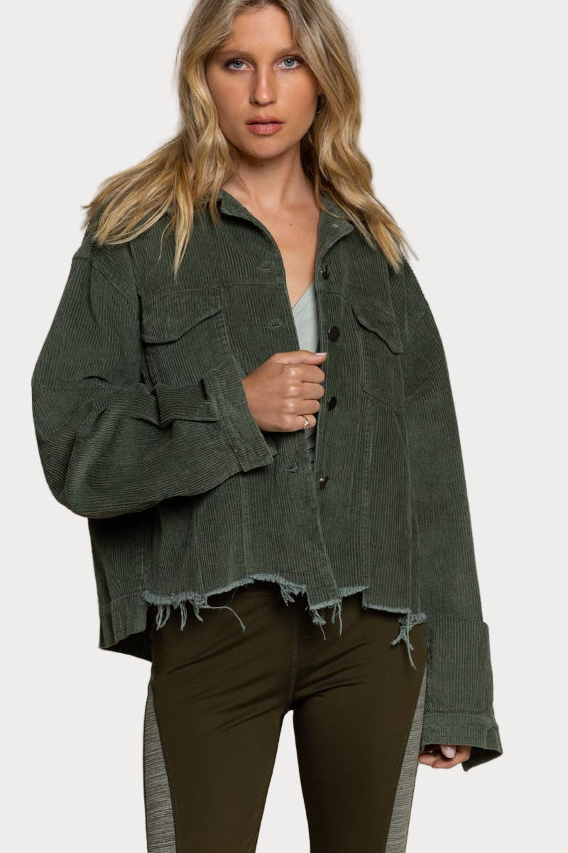 Woman wearing a green jacket and pants against a beige background