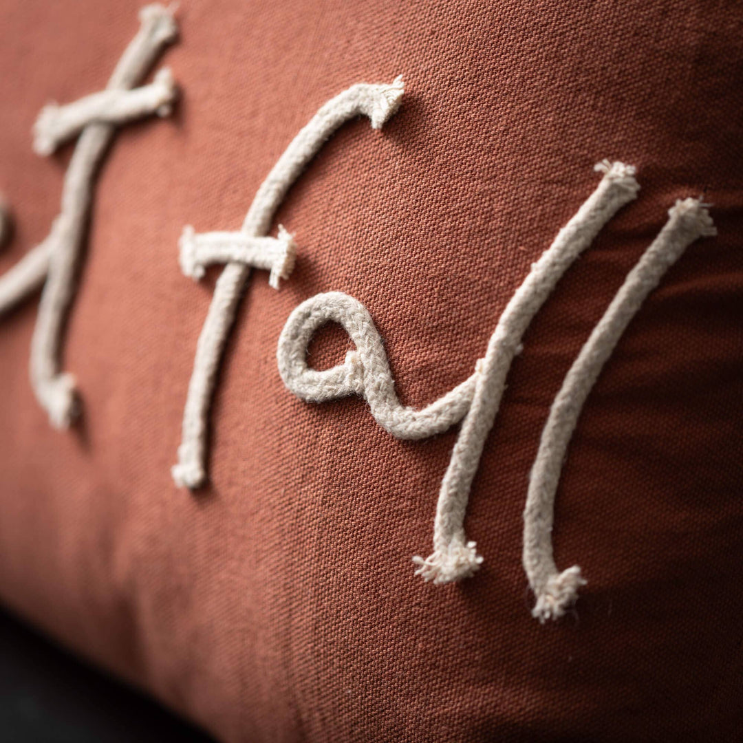 Close-up of a brown fabric with embroidered white text on a dark background