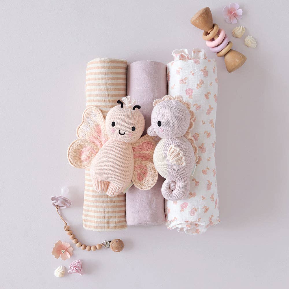 Knit Plush Butterfly & Seahorse, swaddle blankets, and a teething ring on a light background