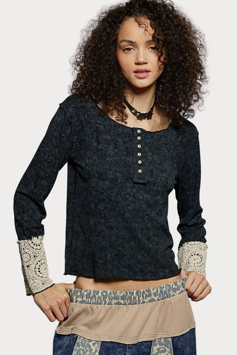 Woman wearing a black long sleeve knit top with cotton lace-trim cuffs and button-front neckline, styled in a feminine boho look.