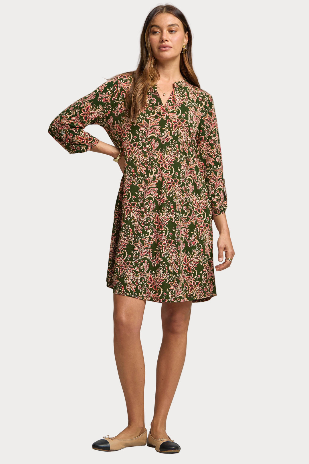 Woman wearing a floral dress against a plain background
