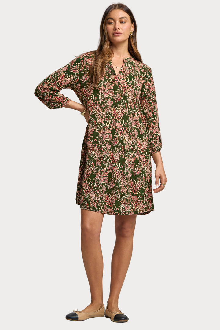 Woman wearing a floral dress against a plain background
