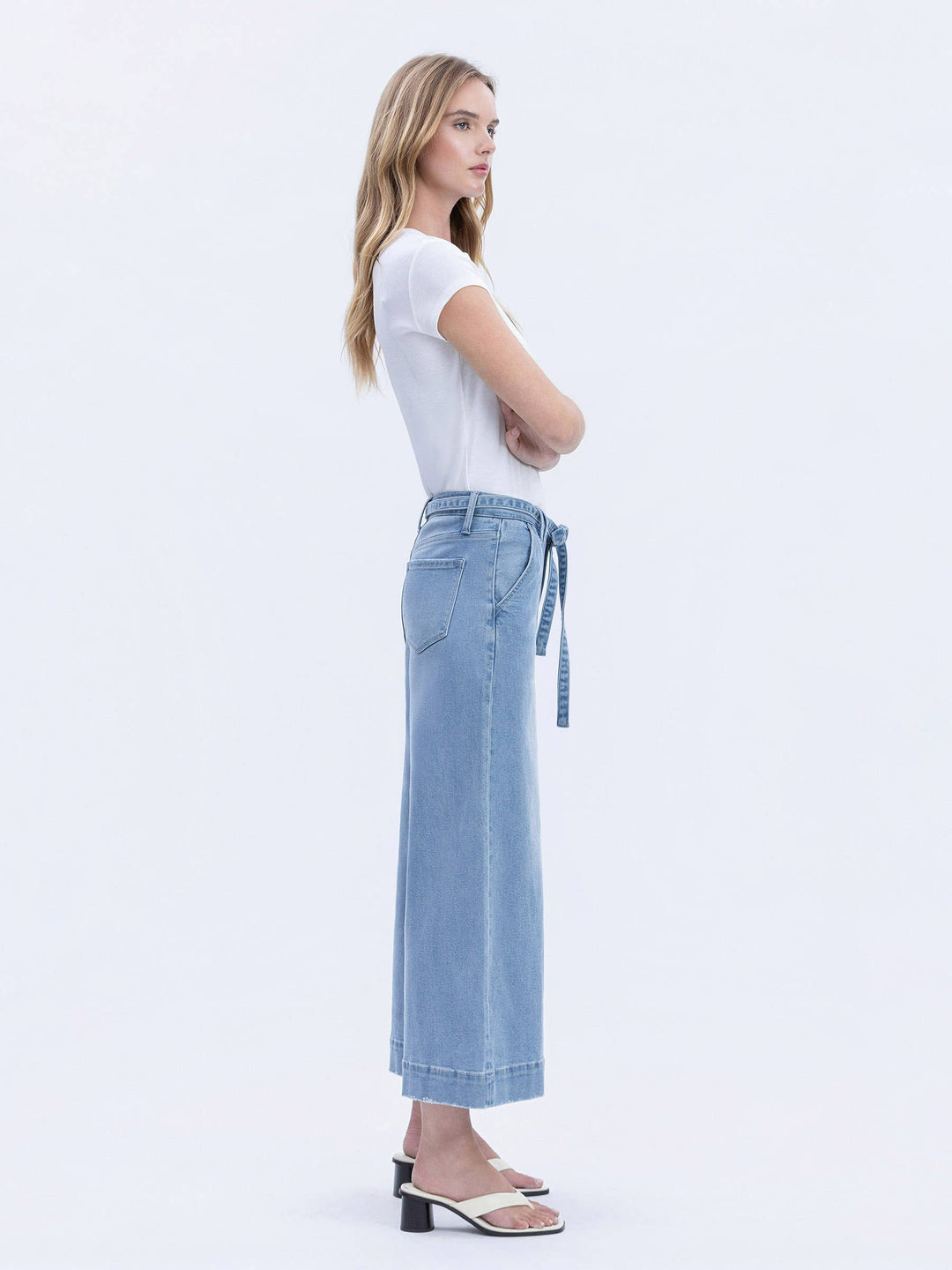Woman wearing a white t-shirt and light blue jeans on a white background