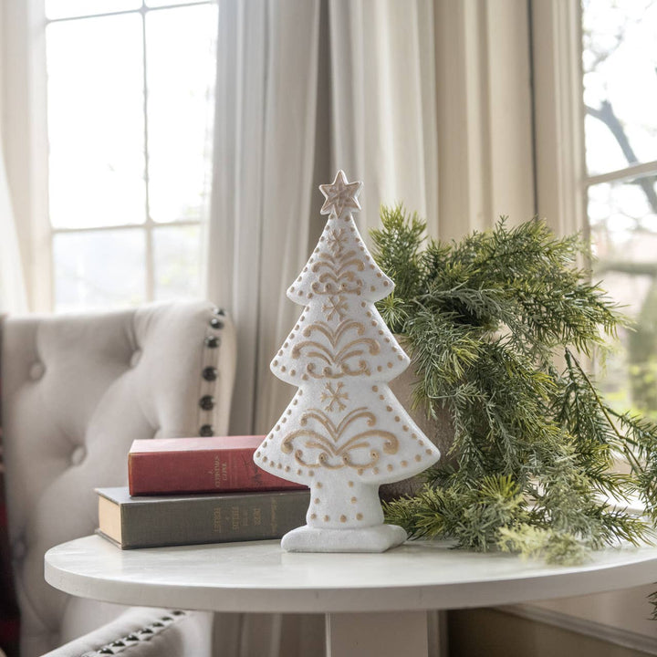 white gingerbread-style decorative Christmas tree with gold detailing on tabletop