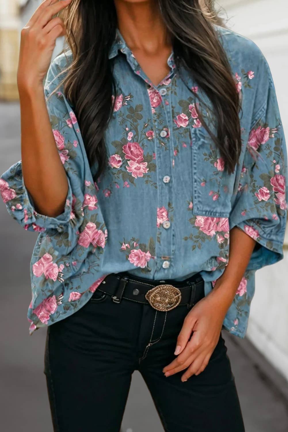 Woman wearing a denim button-up shirt with relaxed 3/4 sleeves and pink floral details.