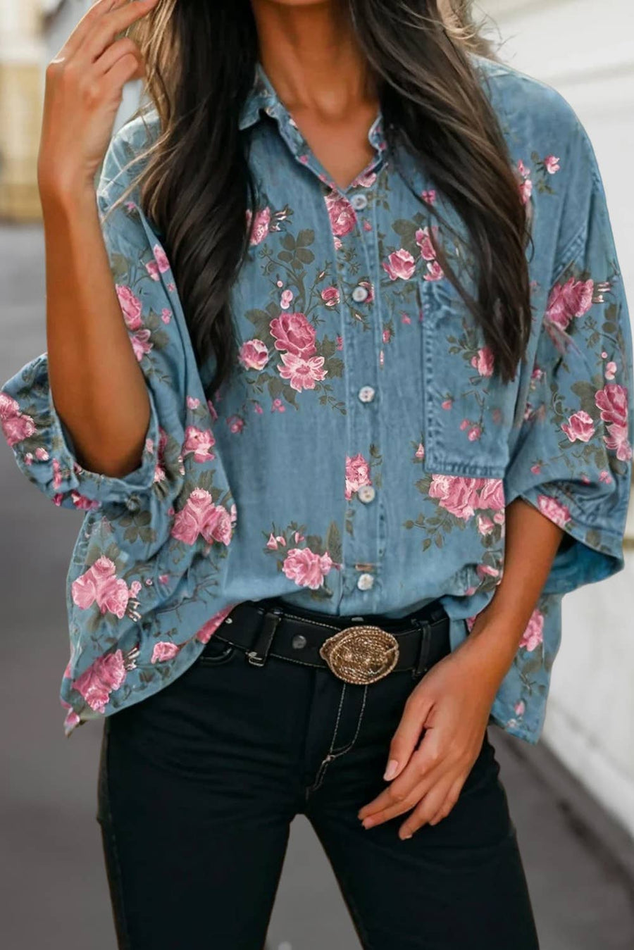 Woman wearing a denim button-up shirt with relaxed 3/4 sleeves and pink floral details.