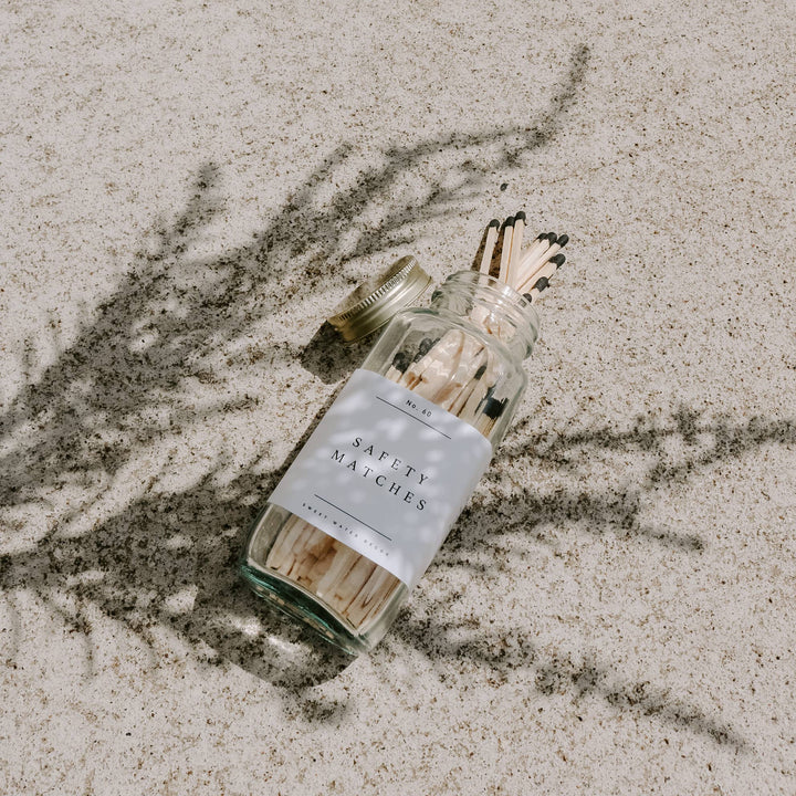 Jar of safety matches on a sandy surface