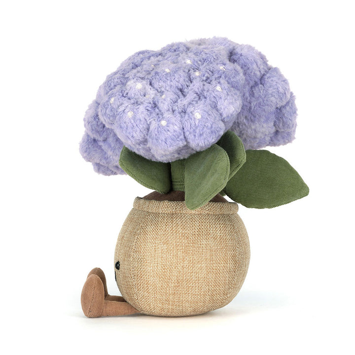 Plush hydrangea plant with purple blooms and smiling pot