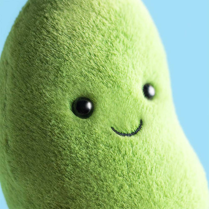Closeup detail of face Amuseables Soyella Edamame Bean plush with soft green fur, smiling face, and brown corduroy feet
