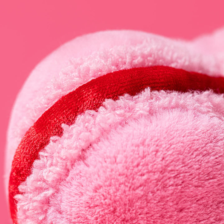 Close up detail shot of Pink heart-shaped amuseable macaron with red filling