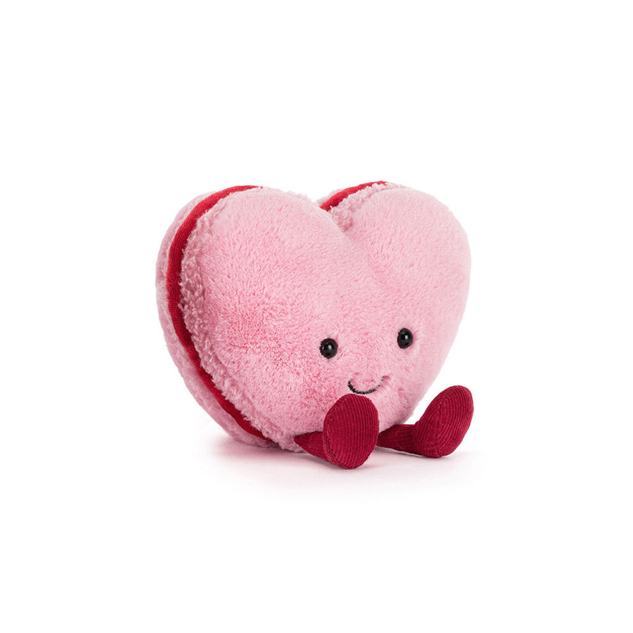 Pink heart-shaped macaron plush with smiling face and red corduroy feet