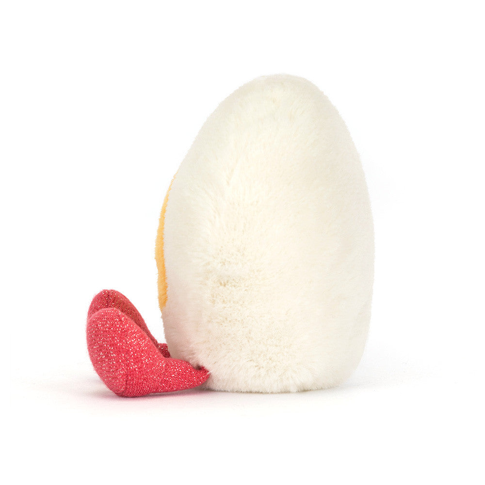 Jellycat Amuseables Heart Boiled Egg plush with cream heart shape, yellow center, stitched smile, and pink feet on a white background facing right