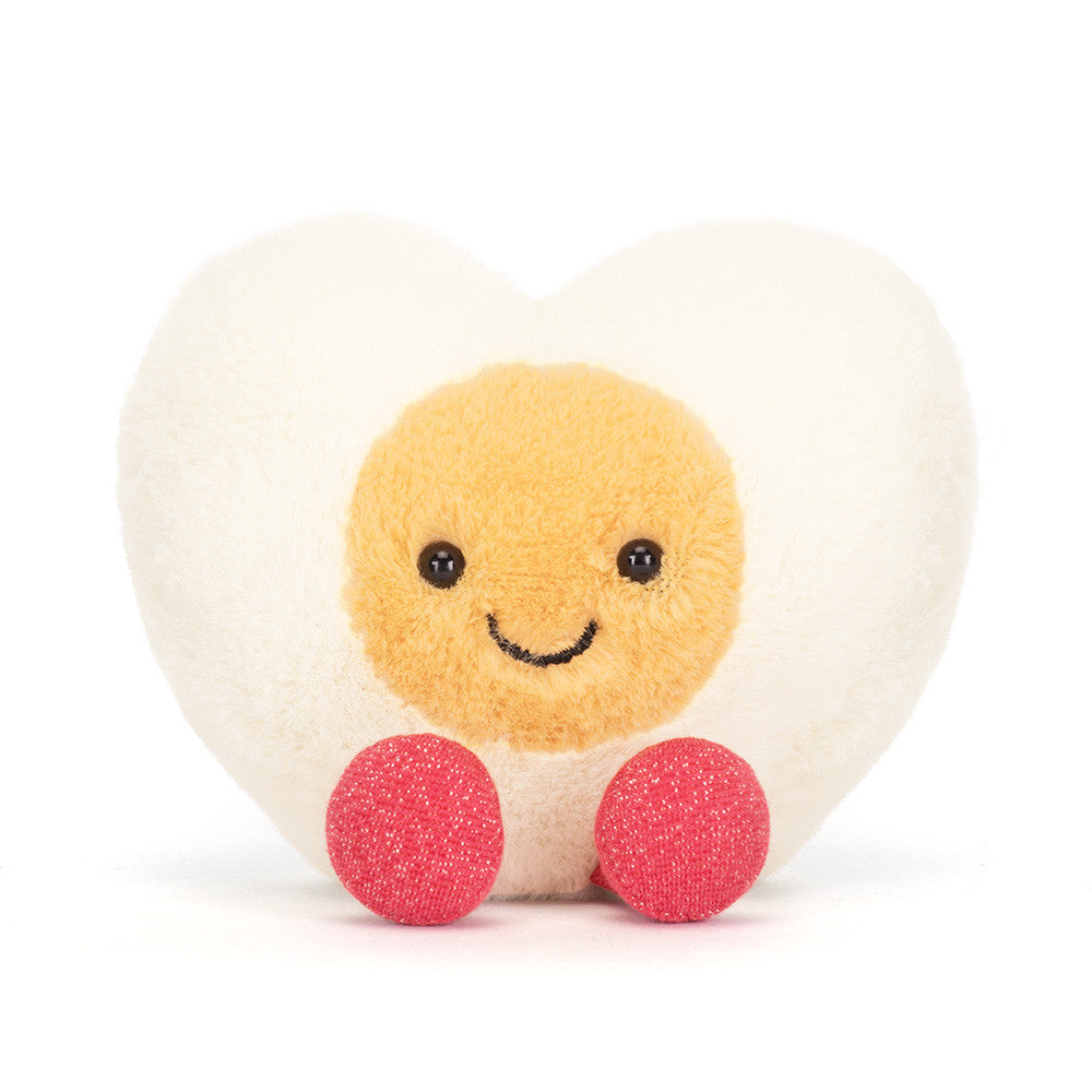 Jellycat Amuseables Heart Boiled Egg plush with cream heart shape, yellow center, stitched smile, and pink feet on a white background