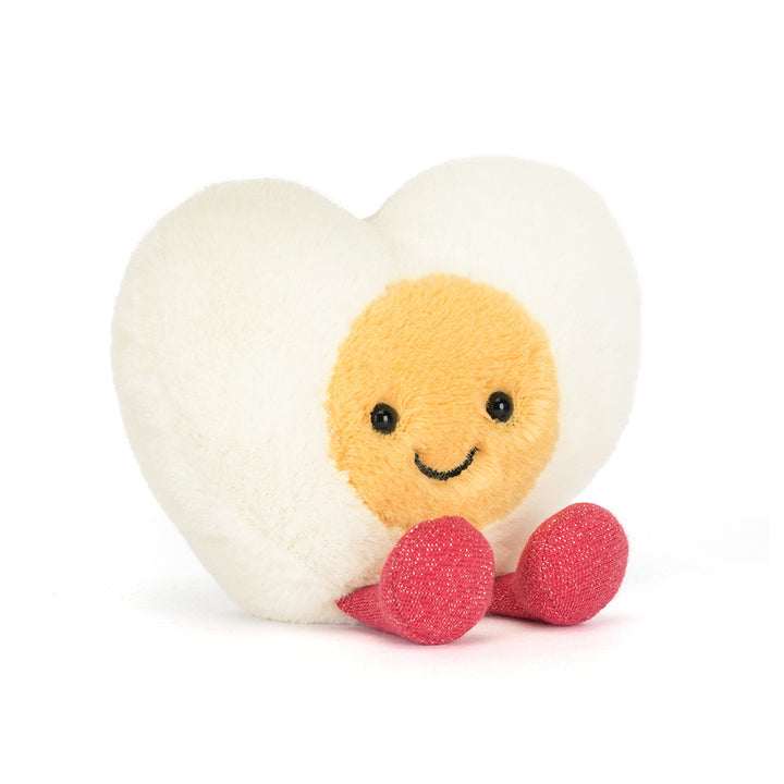 Jellycat Amuseables Heart Boiled Egg plush with cream heart shape, yellow center, stitched smile, and pink feet on a white background