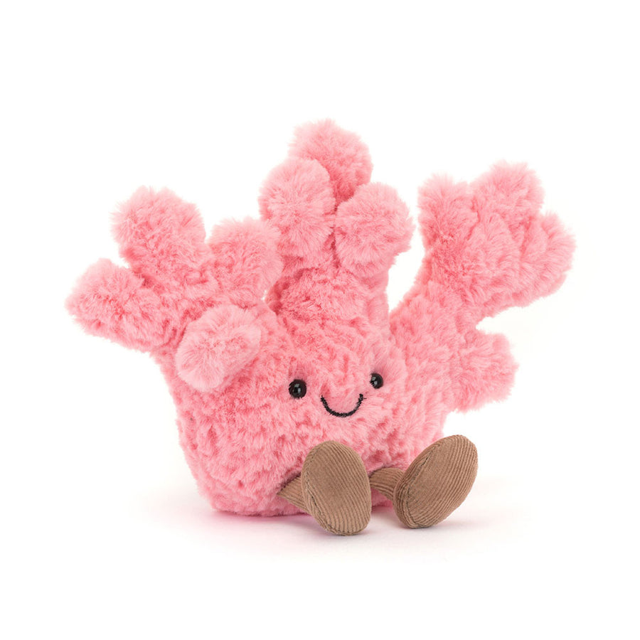 A soft, plush Jellycat Amuseable Coral toy, vibrant pink with a friendly embroidered smile and black eyes, sitting with two corduroy brown feet extended forward, set against a clean white background