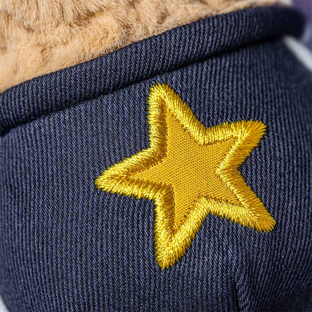 Smiling plush peanut wearing glasses and a star student outfit closeup detail shot of star outfit