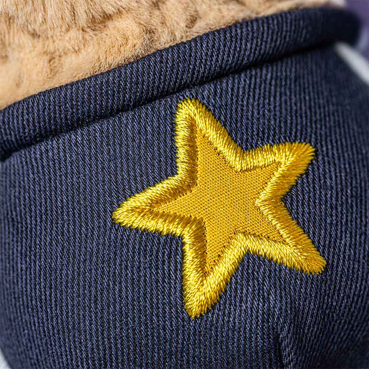 Smiling plush peanut wearing glasses and a star student outfit closeup detail shot of star outfit