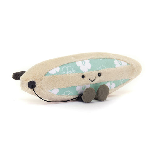 A beige plush surfboard toy from Jellycat's Amuseables Sports collection, featuring a aqua green center with white hibiscus flowers, a happy embroidered face, small brown feet, and a dark grey leash.