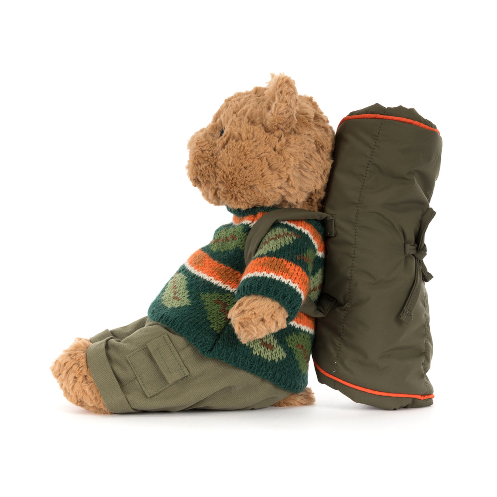 Jellycat Bartholomew Bear Hiking Outfit plush wearing a green woodland sweater, cargo pants, and a camping backpack with a rolled sleeping bag.