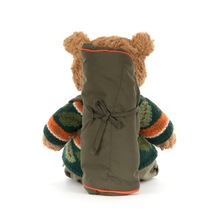 Jellycat Bartholomew Bear Hiking Outfit plush wearing a green woodland sweater, cargo pants, and a camping backpack with a rolled sleeping bag.