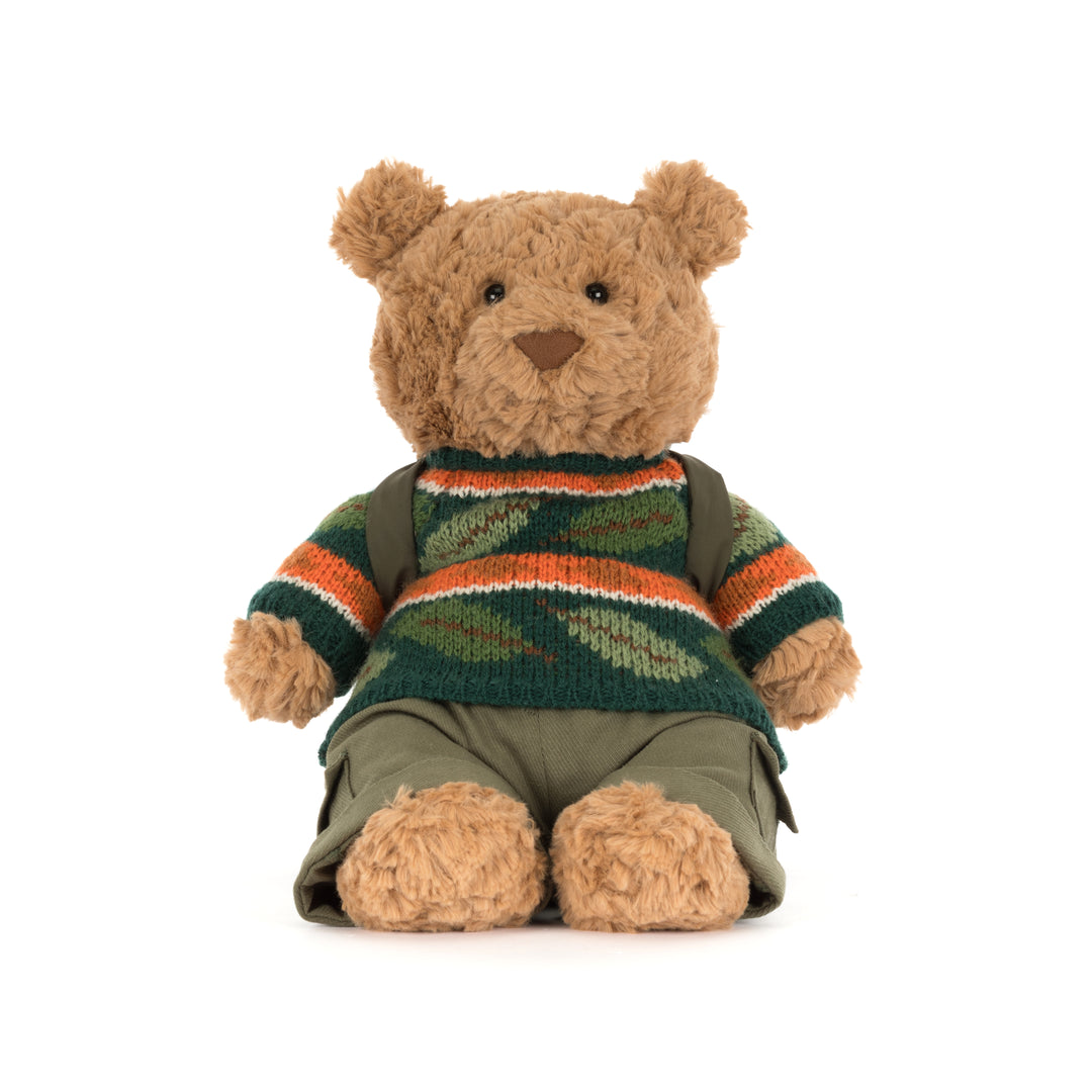 Jellycat Bartholomew Bear Hiking Outfit plush wearing a green woodland sweater, cargo pants, and a camping backpack with a rolled sleeping bag.