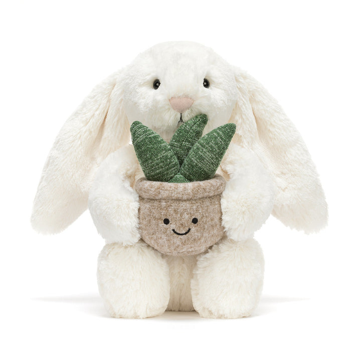 Cream plush bunny holding a smiling potted plant with green leaves