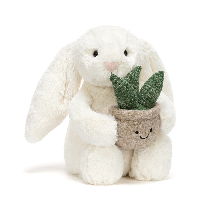 Cream plush bunny holding a smiling potted plant with green leaves