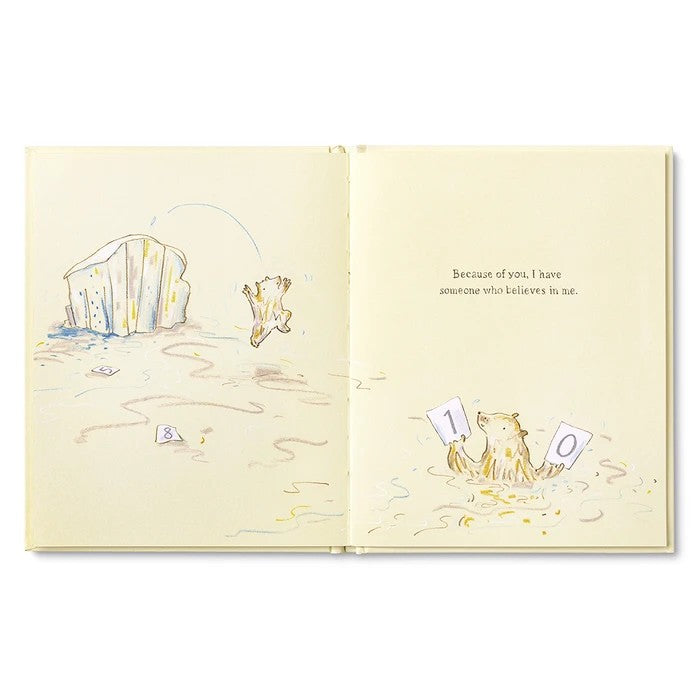 An open children's book spread showing a cream-colored illustrated page with a bear standing on sand near a large rock, plus small text on the right page.