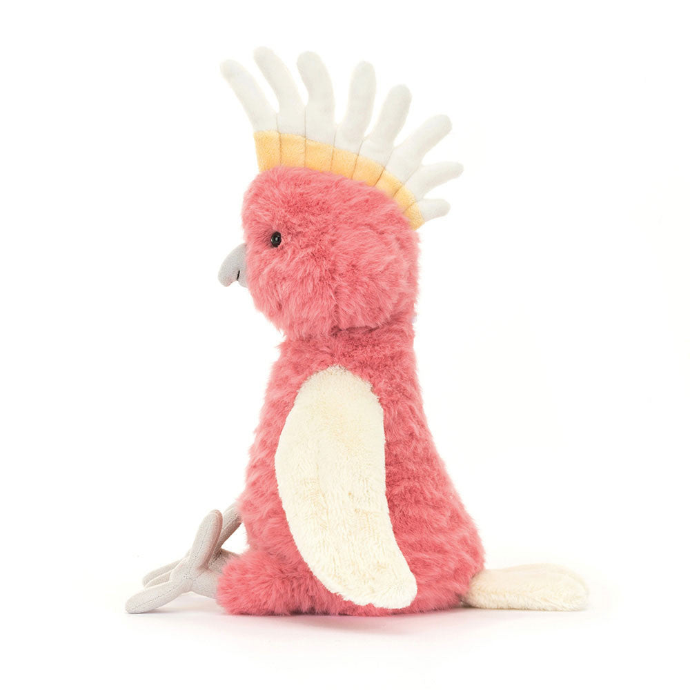 Squawkatoo side view really shows off her crest of cream and pale yellow "feathers". The contrast of her cream wings and coral body. she also has a soft grey beak and feet. 