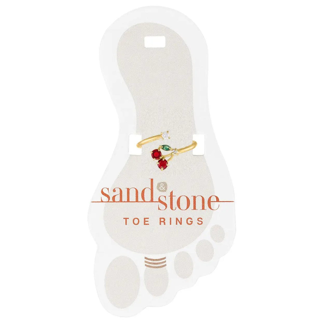 Gold toe ring with cherry design featuring red and green stones on display card