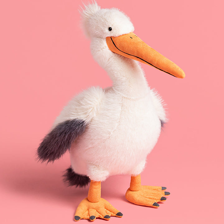 Plush pelican toy on a pink background