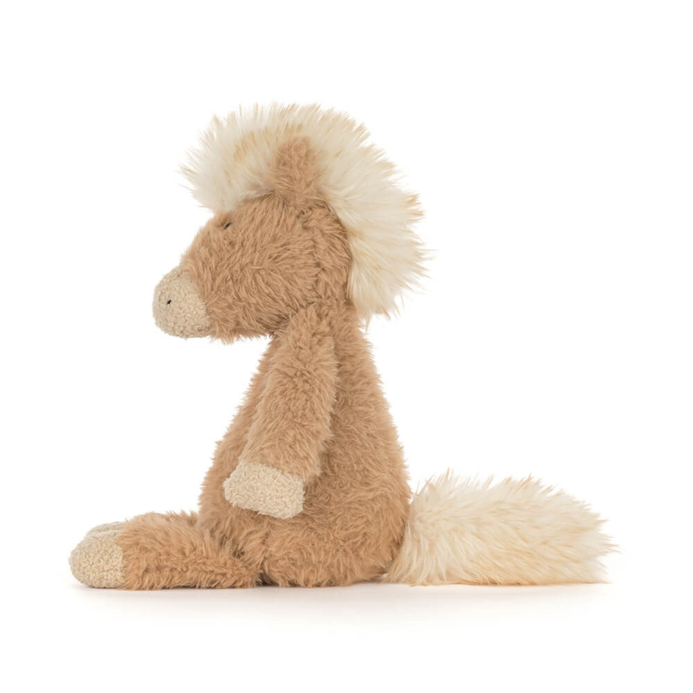 Soft plush pony with tan fur, cream accents, and fluffy mane sitting upright facing left
