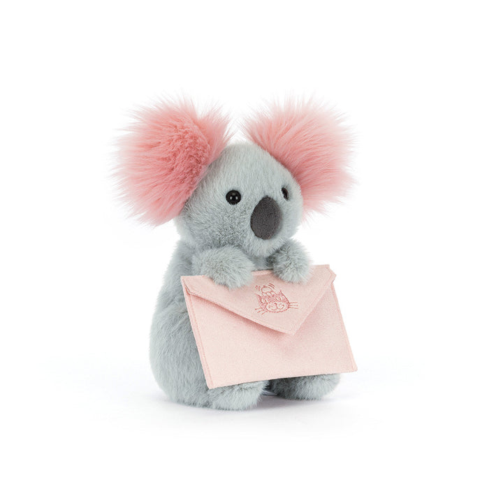 Jellycat Koala plush with fluffy pink ears holding a soft pink message envelope on a white background