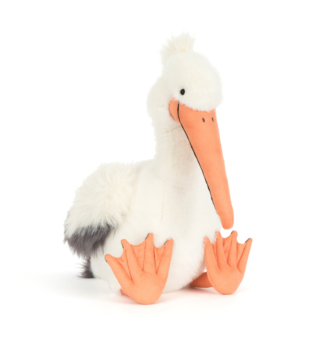Plush toy pelican with a long orange beak on a white background
