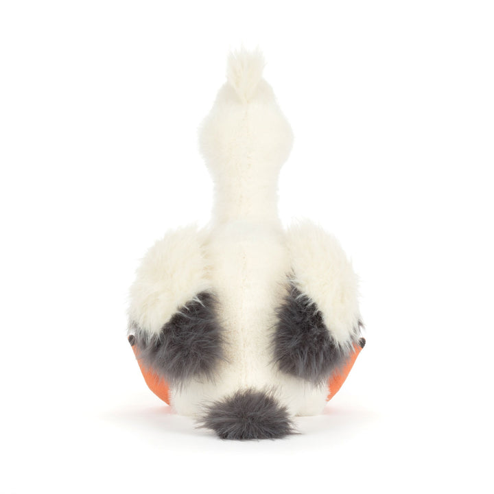 Pelican plush toy with a white body, black spots, and orange feet on a white background. Back view