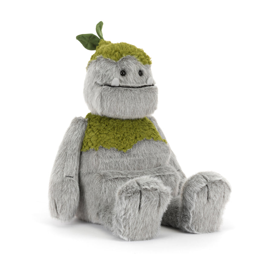Rockleton Jellycat plush with soft gray fur, moss green accents, leafy sprout on its head, oversized feet, and a friendly embroidered smile sitting on a white background.