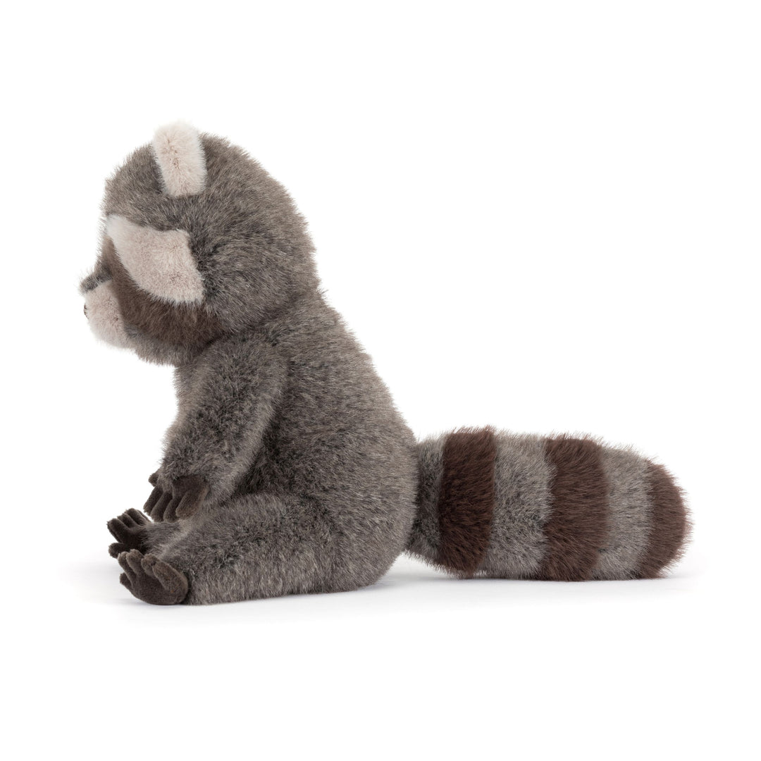Trixiwoo Raccoon Jellycat plush with soft gray fur, fluffy striped tail, masked face, and seated pose on a white background.