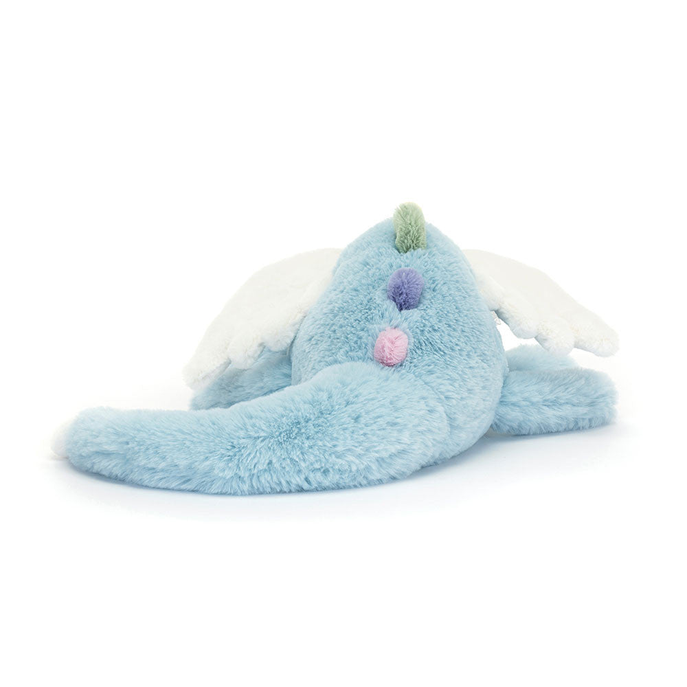 Jellycat Sky Dragon plush with soft blue fur, white wings, and pastel accents lying on a white background rear view