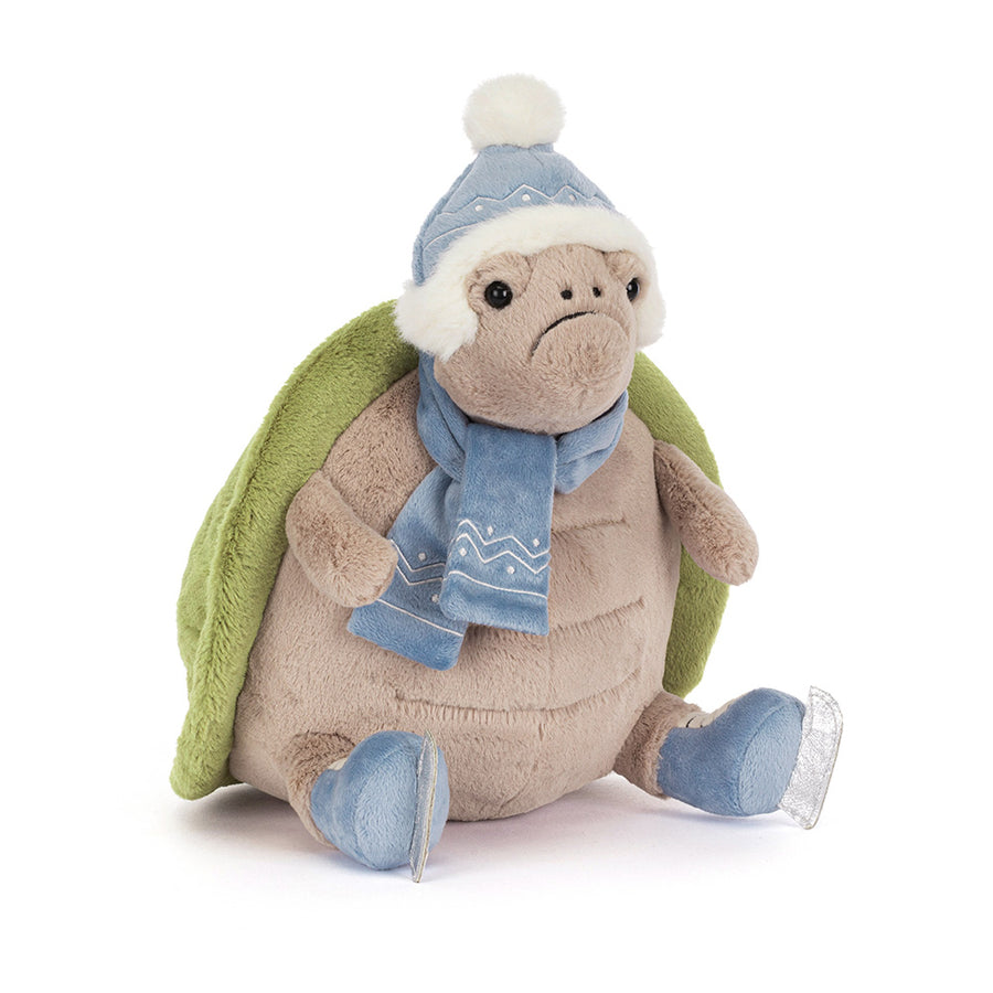 Plush turtle wearing blue winter hat and scarf with silver skates