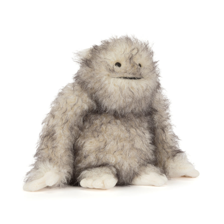 Bretti Yeti Jellycat plush with shaggy cream and gray fur, floppy arms, tiny feet, and a friendly embroidered smile sitting on a white background.