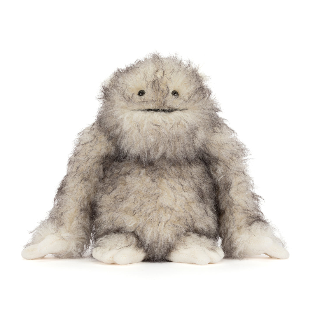 Bretti Yeti Jellycat plush with shaggy cream and gray fur, floppy arms, tiny feet, and a friendly embroidered smile sitting on a white background.