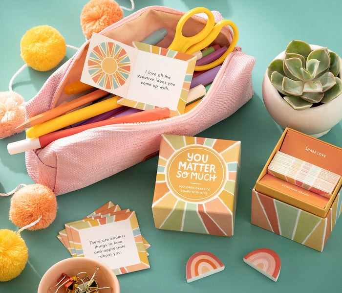 Colorful stationery set with cards and a plant on a teal background