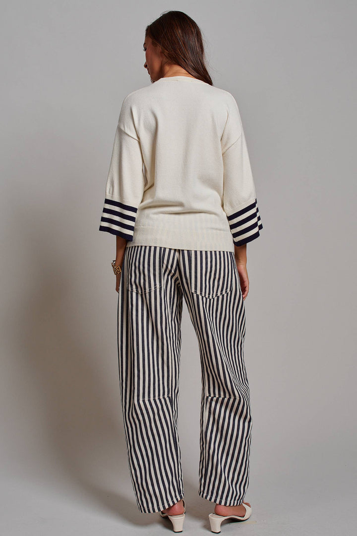 Woman wearing navy and ivory railroad stripe utility pants with oversized patch pockets, braided drawstring waist, and relaxed straight-leg fit.