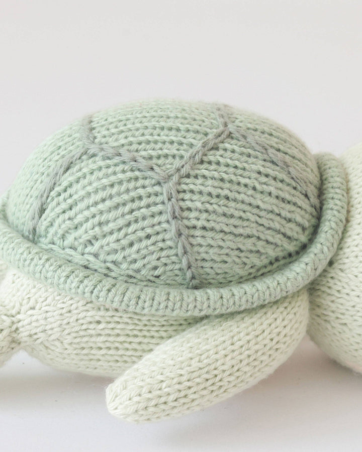 Knitted turtle toy on a white background