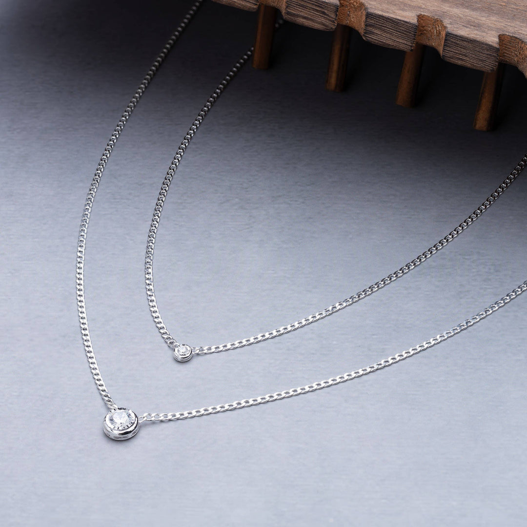 Sterling silver necklace with bezel-set cubic zirconia pendant shown layered with another necklace