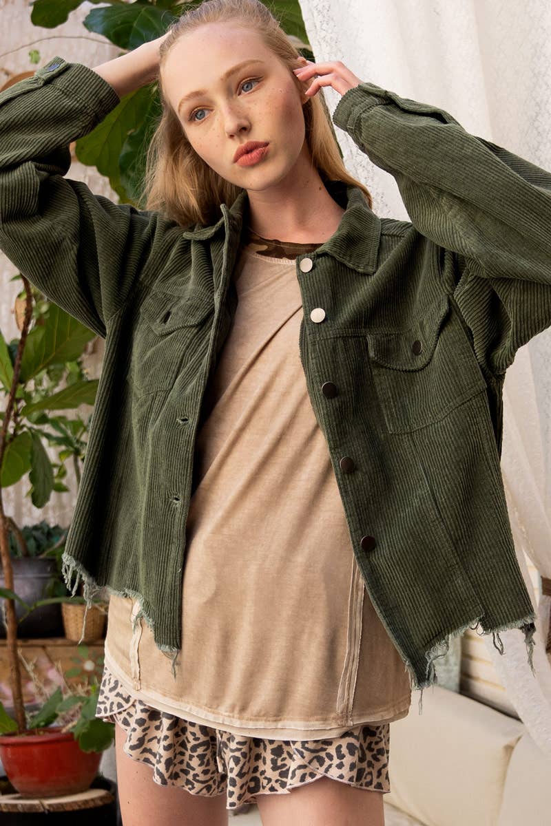 A woman models a relaxed-fit, olive green corduroy jacket with a raw, frayed hem over a tan t-shirt and leopard print shorts.

