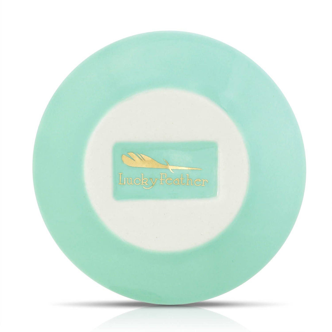 back of Mint green trinket dish with 'Lucky Feather' logo on a white background