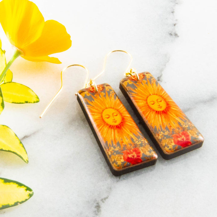 Vintage sunburst tapered rectangle wooden earrings with orange celestial sun and floral artwork
